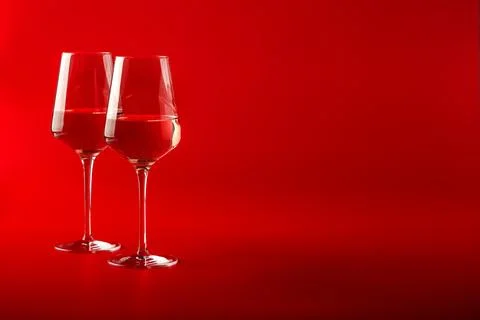 Two full glasses of wine over red background Stock Photos