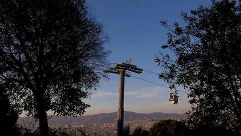 Two funiculars are moving towards each other against the blue sky. Trees in the Stock Footage 101200477