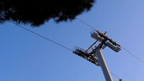 Two funiculars are moving towards each other against the blue sky and green fir Stock Footage 101200598