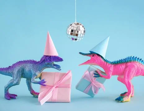 Two funky dinosaurs with gift boxes and disco ball on pink background. Happ.. Stock Photos