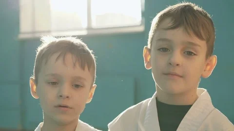 Two funny chipped boys hugging, making faces and laughing to camera in the gym Video stock 75392397
