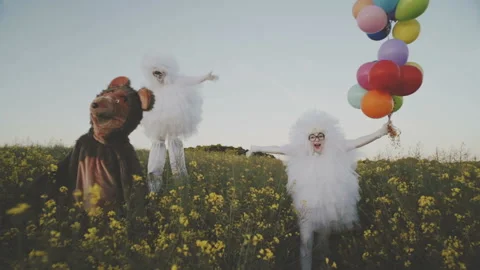 Two funny clowns mime in white air suits and with colored balloons walk around Stock Footage 92181753