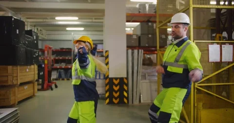 Two funny industrial engineers dancing in warehouse and having fun during break Stock Footage 112058668