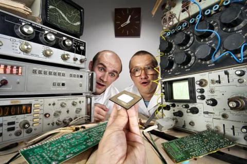 Two funny nerd scientists looking at modern computer processor Foto stock
