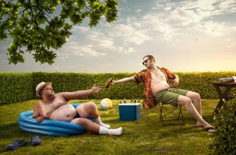 Two funny nerds relaxing in the backyard on the summer day Stock Photos