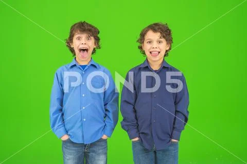 The two funny twin kids grimace on the green background Stock Photos