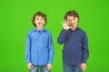The two funny twin kids stand on the green background Photo