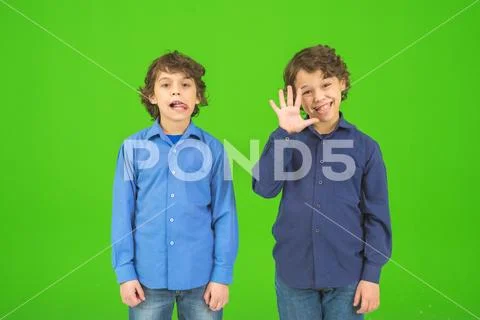 The two funny twin kids stand on the green background Stock Photos