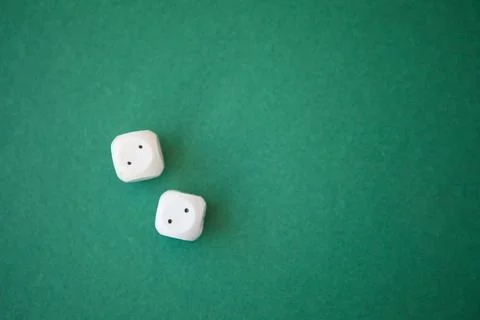 Two game dices, two white tiles on green background Stock Photos