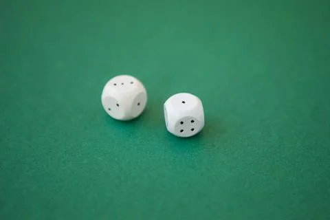 Two game dices, two white tiles on green background Stock Photos