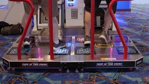 Two gamers dancing on rhythm game Pump It Up 4k 库存影片 282135476