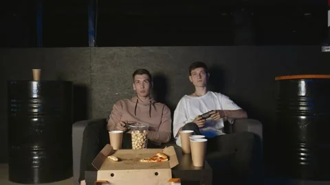 Two gamers in front of the screen are playing together in the online battle Video stock 136339209