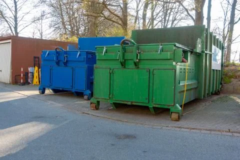 Two garbage compactors are standing in the courtyard of a hospital Stock Photos