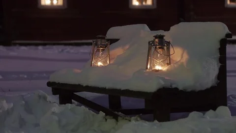 Two gas lanterns on a bench covered in snow Video stock 69834931