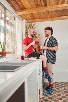 Two gay men in the kitchen drinking coffee Stock Photos