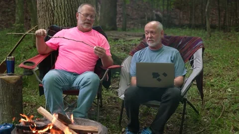 Two gay men with pride flag and tent in tent talking to laptop on video chat. Video stock 166394493