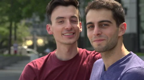 Two gay men talk on a bench and look at camera. Stock Footage 44110695