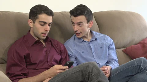Two gay men talk, while one is on his phone. Stock Footage 44111175