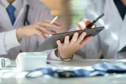 Two general practitioners discussing illnesses treatment or health test res.. Stock Photos