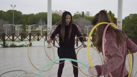 Two Generation Z women playing with Hula Hoop rings 库存影片 130436053