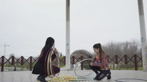 Two Generation Z women playing with Hula Hoop rings 库存影片 130441237