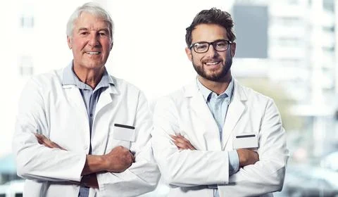 Two generations of doctors. Portrait of two cheerful male scientists standing Stock Photos