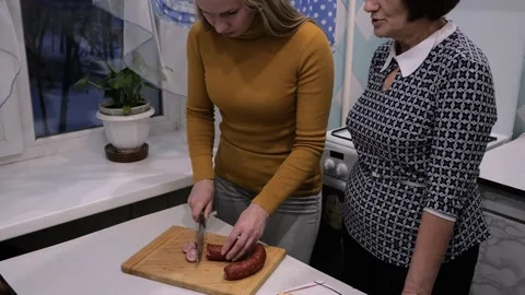 Two generations in kitchen. Mother teaches her daughter to cook Stock Footage 169028629
