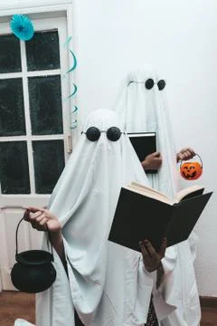 Two ghost reading black mock up books for halloween holding cauldrons and pum Stock Photos