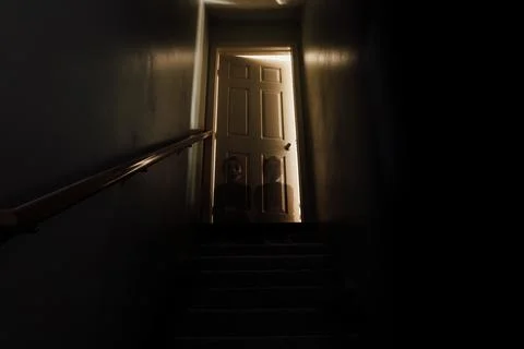 Two ghostly figures sit at the top of darkly lit steps Stockfoto's