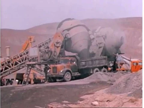 Two giant concrete mixers at a batch plant near a new highway construction site Stock Footage 74974590