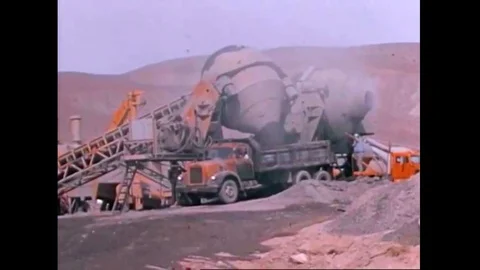 Two giant concrete mixers at a batch plant near a new highway construction site Stock Footage 141597905
