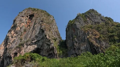 Two giant limestone cliffs in bright sunny morning on Kolipe Island Video stock 339904735