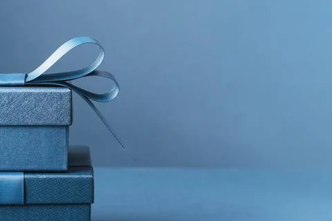 Two gift boxes with a blue bow on blue monochrome Foto stock