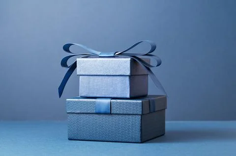 Two gift boxes with a blue bow on blue monochrome Stock Photos