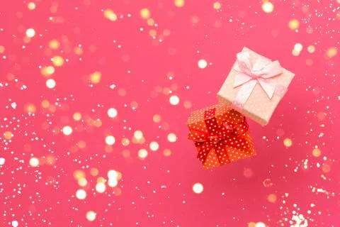 Two gift boxes on a bright pink background with gold bokeh lights Stock Photos