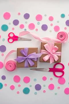 Two gift boxes on festive pastel confetti background. Stock Photos