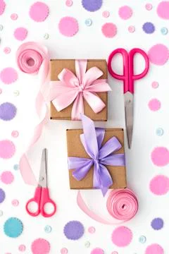 Two gift boxes on festive pastel confetti background. Stock Photos