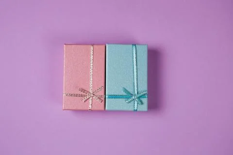 Two gift boxes, presents, pink and turquoise on the violet background. Stock Photos