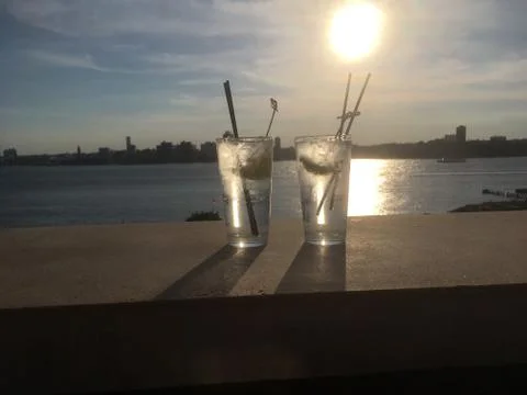 Two gin and tonics with lime and straws on the ledge of a rooftop bar Stock Photos