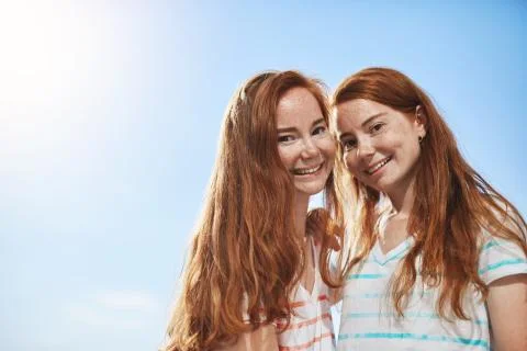 Two ginger girls looking at camera smiling on a sunny summer day. Having a twin Stock Photos