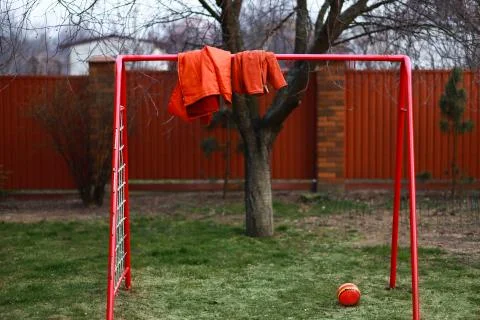 Two ginger red jakets hand on a soccer gate Stock Photos
