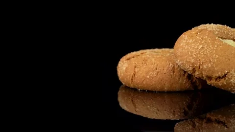 Two Ginger Snap Cookies Rotating on Turntable with Camera Pan on Dark Background Stock Footage 330514648
