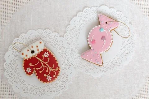 Two gingerbread cookies in the shape of candy and red mitten on a white napkin Stock Photos