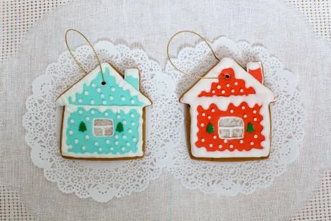 Two gingerbread cookies in the shape of the small cottage on a white napkin Stock Photos