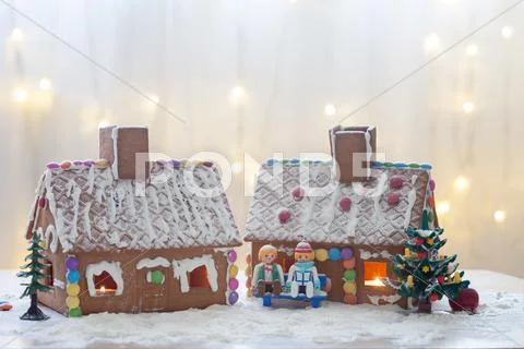 Two gingerbread houses, tree and people sitting on a bench, winter scene Stock Photos