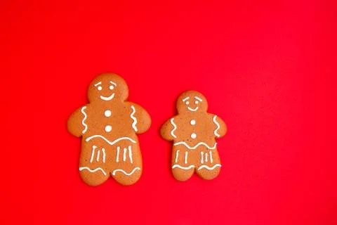 Two gingerbread mans on bright red festive background Stock Photos