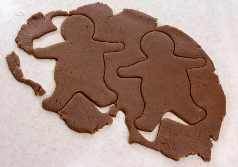 Two gingerbread men in cookie dough Stock Photos
