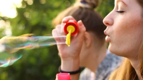 Two girl blowing bubbles Stock Footage 64990312