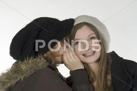 Two girl friends (13-14) whispering, portrait Stock Photos