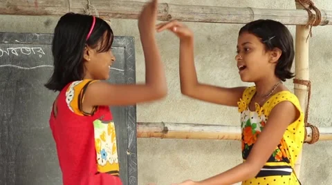 Two girl students play a clapping game in a village school in Bengal, India. Stock Footage 65801552